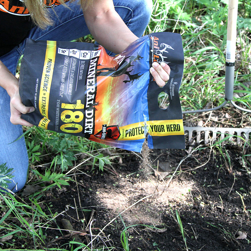 Woman pouring out a 10 lb. bag of Mineral Dirt 180 onto the ground