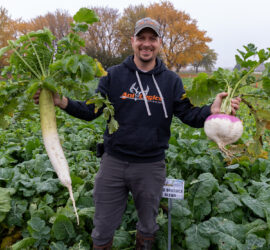 Tim Neuman smiling with harvests from a Pro Brassica Blend food plot