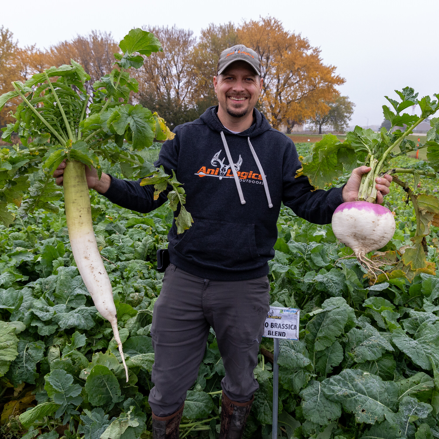 Tim Neuman smiling with harvests from a Pro Brassica Blend food plot