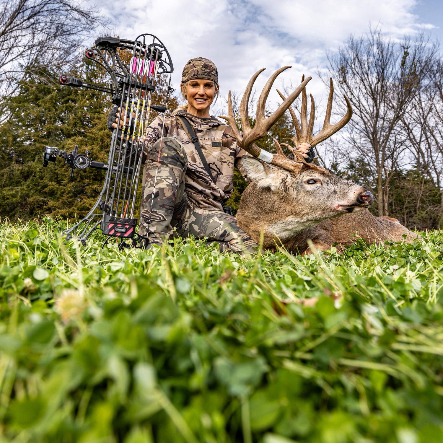 Tiffany Lakosky with big buck in a food plot planted with CRUSH Clover Plus Alfalfa