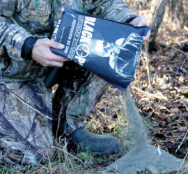 Bag of Black Ops Granular Attractant being poured onto the ground