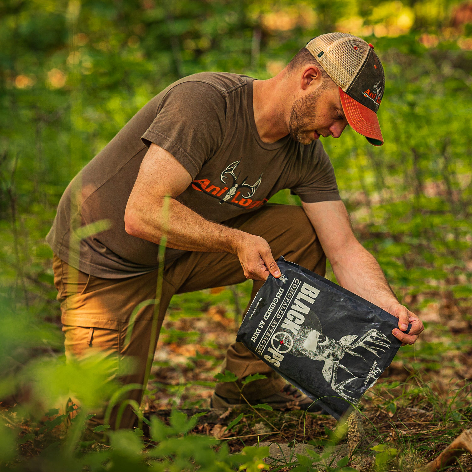 Man pouring a bag of Black Ops Granular Attractant onto the ground