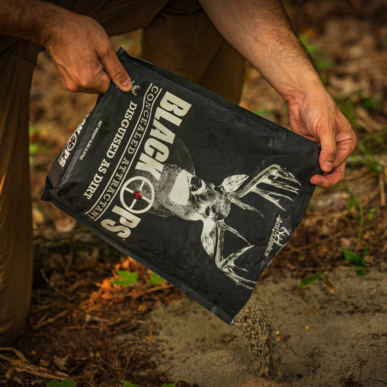 Man pouring a bag of Black Ops Granular Attractant onto the ground