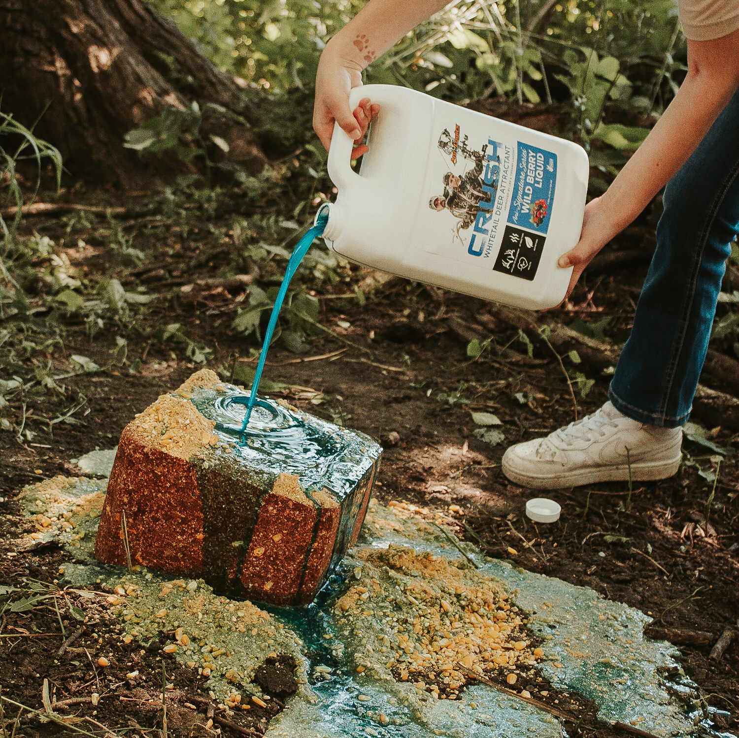 CRUSH Wild Berry Liquid attractant being poured onto a Wild Berry Block