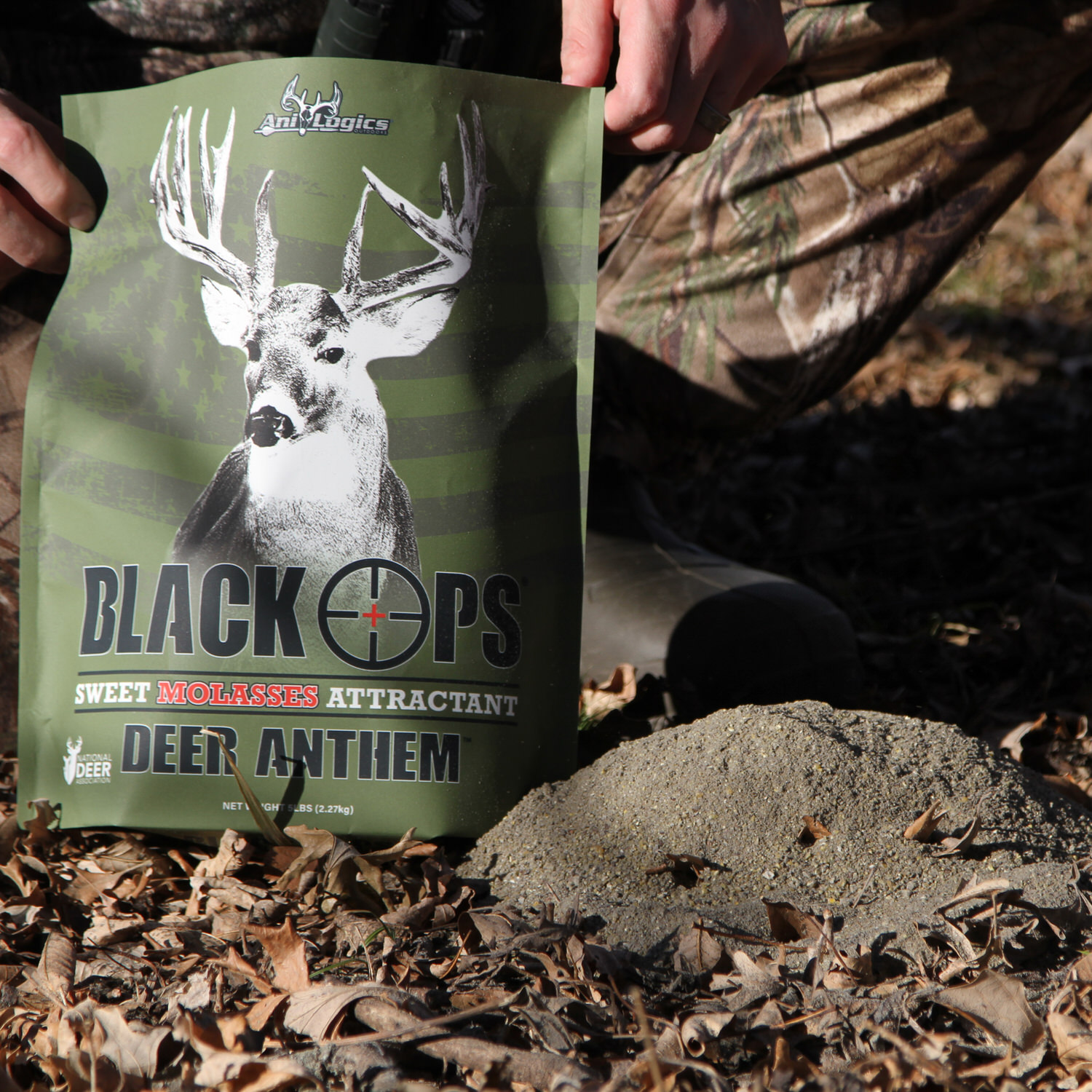 Black Ops Deer Anthem Molasses Granular Attractant bag next to mound of it poured onto the ground