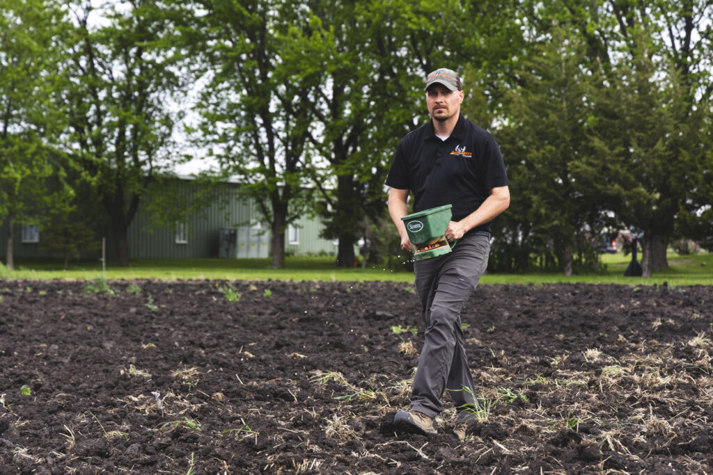 Tim Neuman hand broadcasting seeds for his fall food plots