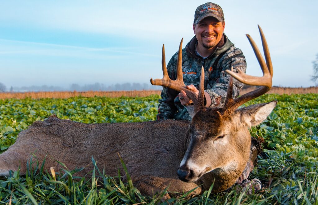 Tim Neuman posed with Bogtrotter buck in food plot fields