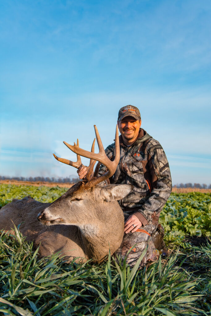 Tim Neuman posed with Bogtrotter buck in food plot fields