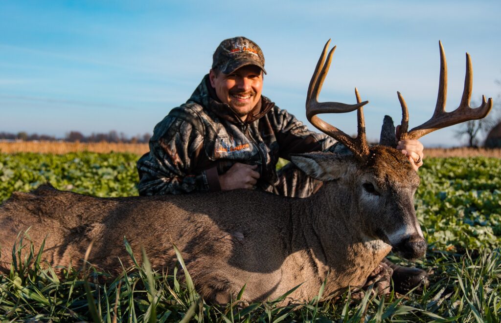 Tim Neuman posed with Bogtrotter buck in food plot fields